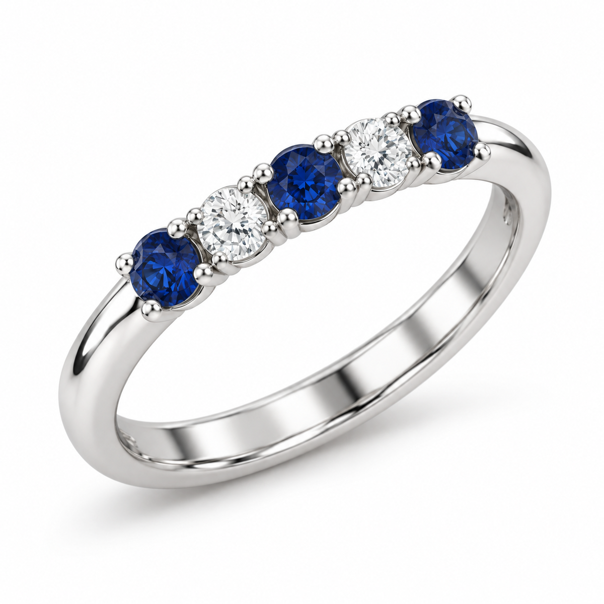 [metal:white-gold] Amelie Sapphire Accent Band — three-quarter — slender polished band with five round stones across front ordered blue sapphire white diamond blue sapphire white diamond blue sapphire, three-quarter view [catalog-v4]
