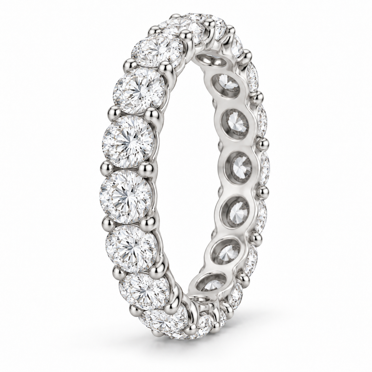 [metal:white-gold] Aveline Round Eternity Ring — three-quarter — Shared-prong round diamond eternity ring, standing oblique studio view [catalog-v4]