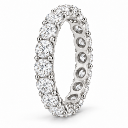[metal:white-gold] Aveline Round Eternity Ring — three-quarter — Shared-prong round diamond eternity ring, standing oblique studio view [catalog-v4]