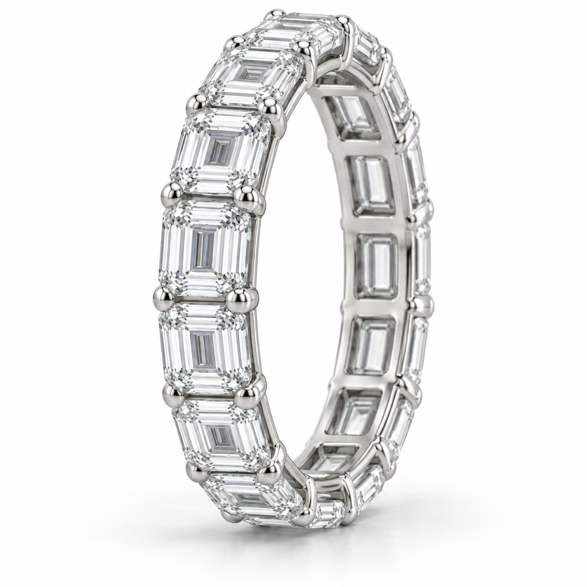 [metal:white-gold] Brielle Emerald Eternity Ring — three-quarter — East-west emerald-cut diamond eternity ring, standing oblique studio view [catalog-v4]