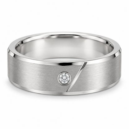 [metal:white-gold] Caedmon Diagonal Bezel Band — front — Mens 6 mm flat satin wedding band, exactly one small round diamond in a flush circular bezel on front, a short narrow engraved diagonal polished line runs beside but does not cross diamond. Thin polished bevel edges, smooth circular comfort-fit bore. No other stones. [catalog-v4]