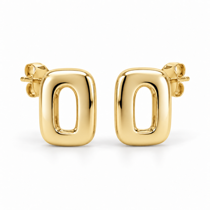 [metal:yellow-gold] Ilorine Arc-Window Studs — front — Matching pair of small thick polished rounded-rectangle metal studs, each has one narrow curved arch-shaped open window through centre. Smooth solid outer perimeter, straight rear posts and butterfly backs. No stones. [catalog-v4]