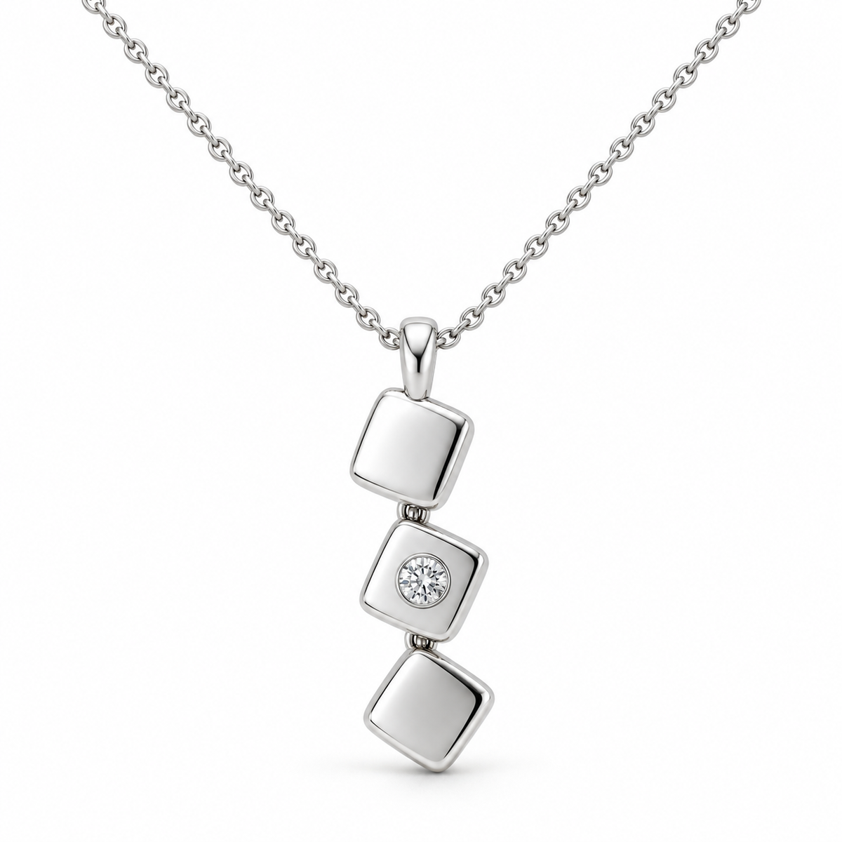 [metal:white-gold] Iserelle Offset Tile Necklace — front — Three small solid polished rounded-square metal tiles in a stepped diagonal cascade, hinged by tiny concealed links, each tile rotated slightly differently. Middle tile alone has one small flush-set round diamond. Fine cable chain through top tile bail. [catalog-v4]