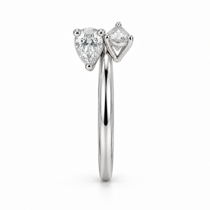 [metal:white-gold] Maribel Pear Duo Ring — side-profile — slender open polished ring with two modest pear diamonds at opposing tips, one pear points up other down, side-profile view [catalog-v4]
