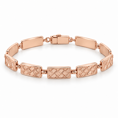 [metal:rose-gold] Miravelle Woven-Panel Bracelet — front — Articulated bracelet of exactly seven short solid rectangular panels. Each panel has a low relief engraved diagonal basket-weave pattern, smooth polished border and plain back, joined by simple short oval links. Low box clasp at rear. No diamonds. [catalog-v4]
