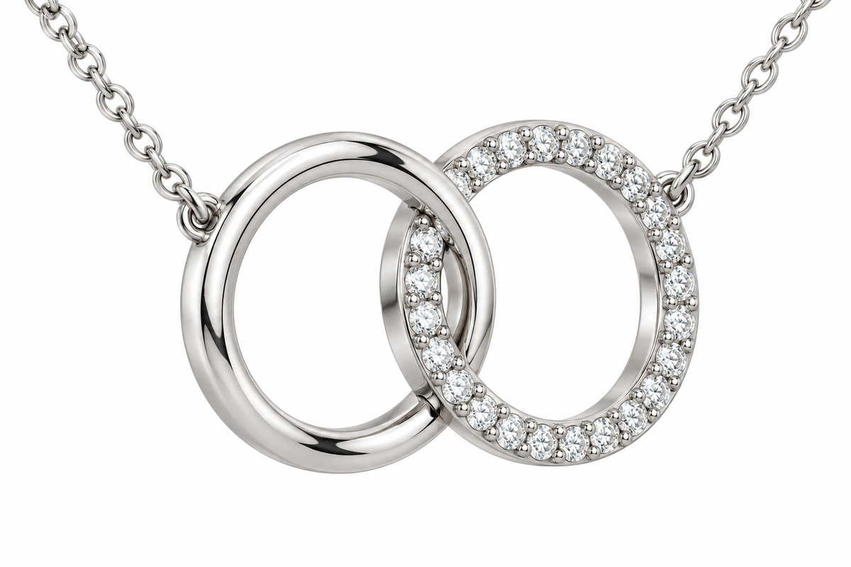 [metal:white-gold] Mirelle Double Circle Necklace — three-quarter — two small interlocking circular pendants one plain polished and one fine round-diamond pave, fine chain attached at upper outer sides, three-quarter view [catalog-v4]
