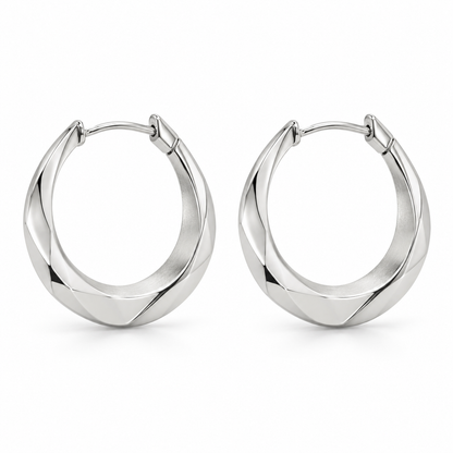 [metal:white-gold] Naverie Facet Crescent Hoops — front — Matching pair of small hinged crescent hoops with solid triangular faceted metal cross-section, narrow at ends and broader along lower front arc. Polished exterior facets, satin inner facet, hinged rear latch. No stones, no open front gap when closed. [catalog-v4]