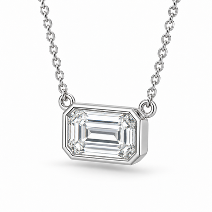 [metal:white-gold] Odette Emerald Pendant — three-quarter — East-west emerald-cut bezel pendant, oblique studio view [catalog-v4]