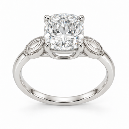 [metal:white-gold] Ophira Cartouche Solitaire Setting — front — One cushion centre in four corner claws in a compact open basket. At each shoulder a single small solid polished oval cartouche inset with engraved concentric oval lines, no stones. Cartouches lie flat along the top of the shank, merge into one slim plain band. Fine bead border on cartouches only, open U bridge beneath centre. [catalog-v4]