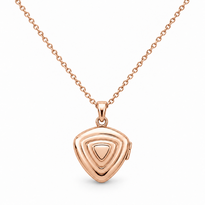 [metal:rose-gold] Orelisse Ripple Locket Necklace — front — One small closed rounded-triangle locket with three shallow concentric rounded-triangle ripples on its front, smooth back, discreet hinge on right edge and a small simple round bail. Fine cable chain. No engraving or stones. [catalog-v4]