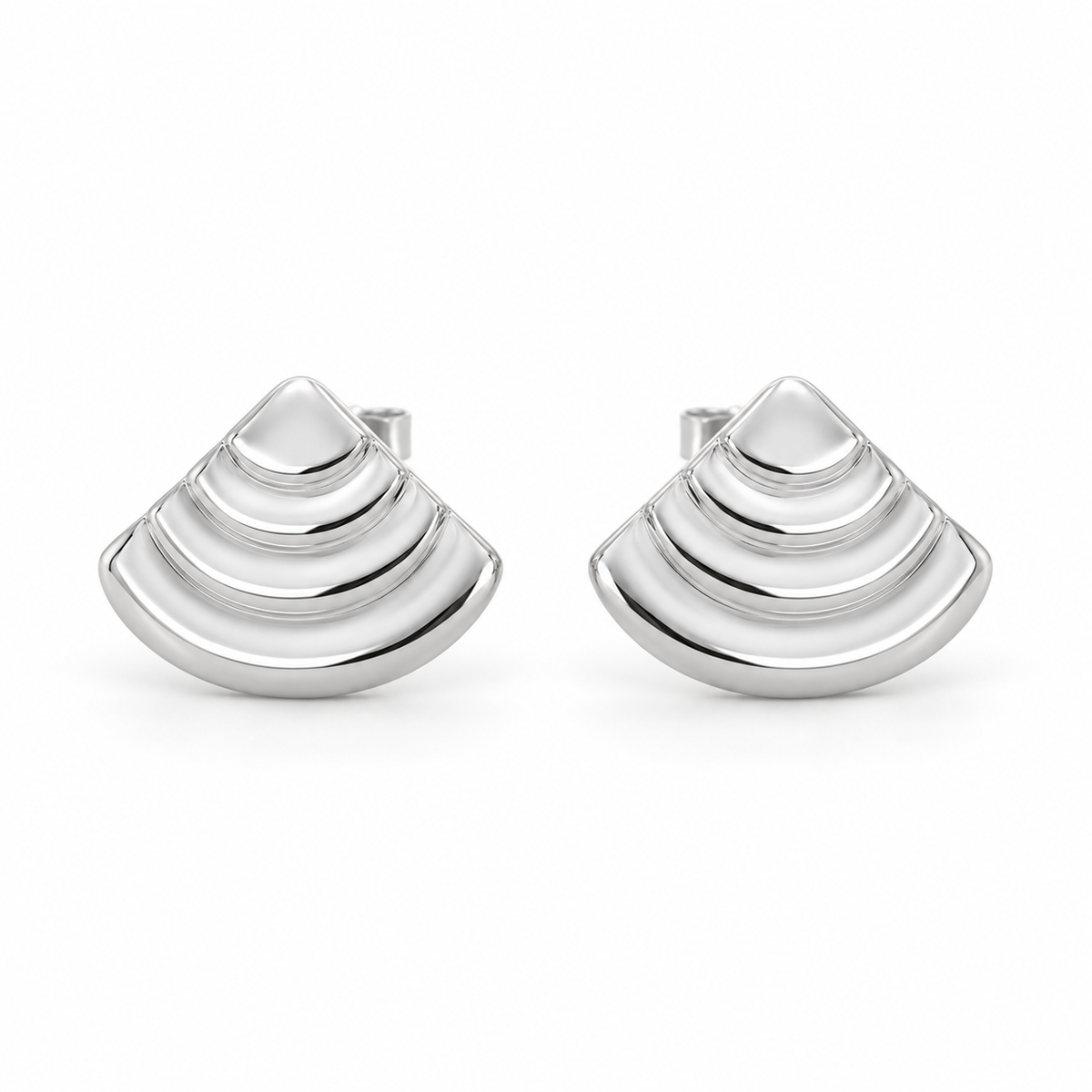 [metal:white-gold] Rovelle Stepped Shell Studs — front — Matching pair of shallow domed fan-shell metal studs, each shell has exactly four broad concentric stepped arc terraces, smooth rounded lower edge and no radial pleats. Straight rear post and butterfly back. No diamonds. [catalog-v4]