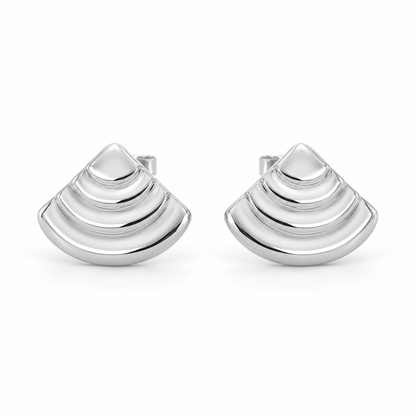 [metal:white-gold] Rovelle Stepped Shell Studs — front — Matching pair of shallow domed fan-shell metal studs, each shell has exactly four broad concentric stepped arc terraces, smooth rounded lower edge and no radial pleats. Straight rear post and butterfly back. No diamonds. [catalog-v4]