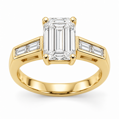 [metal:yellow-gold] Talisse Window Channel Setting — front — One north-south emerald-cut centre in four corner claws over a simple rectangular open basket. Each straight flat shoulder contains exactly two north-south baguette accents in one short straight channel with raised smooth rails. Beneath that channel is one small rectangular side window with a solid lower support. Plain single lower shank. Four baguette accents total. [catalog-v4]