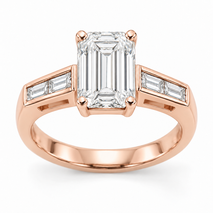 [metal:rose-gold] Talisse Window Channel Setting — front — One north-south emerald-cut centre in four corner claws over a simple rectangular open basket. Each straight flat shoulder contains exactly two north-south baguette accents in one short straight channel with raised smooth rails. Beneath that channel is one small rectangular side window with a solid lower support. Plain single lower shank. Four baguette accents total. [catalog-v4]