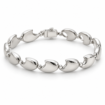 [metal:white-gold] Tavelle Crescent-Link Bracelet — front — Exactly nine identical broad polished crescent-shaped solid links, each crescent tips joined to the next by one small round connector. Crescents all face same direction along chain; clasp at rear. No diamonds. [catalog-v4]